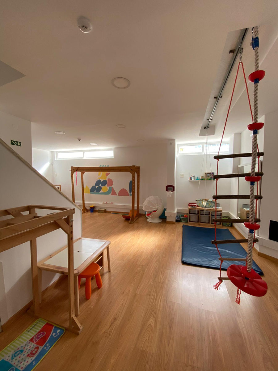 Sala de terapia do Desenvolve-T com escada de cordas, baloiço e tapetes